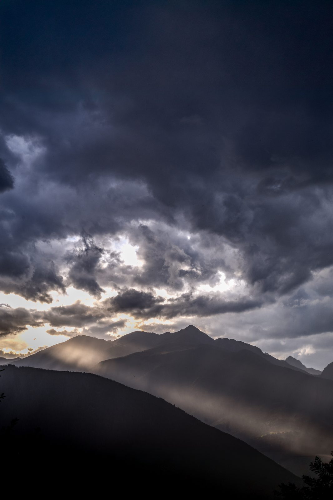 Wolkenstimmung – dramatische Gewitterwolken mit durchbrechendem Licht über den Bergen