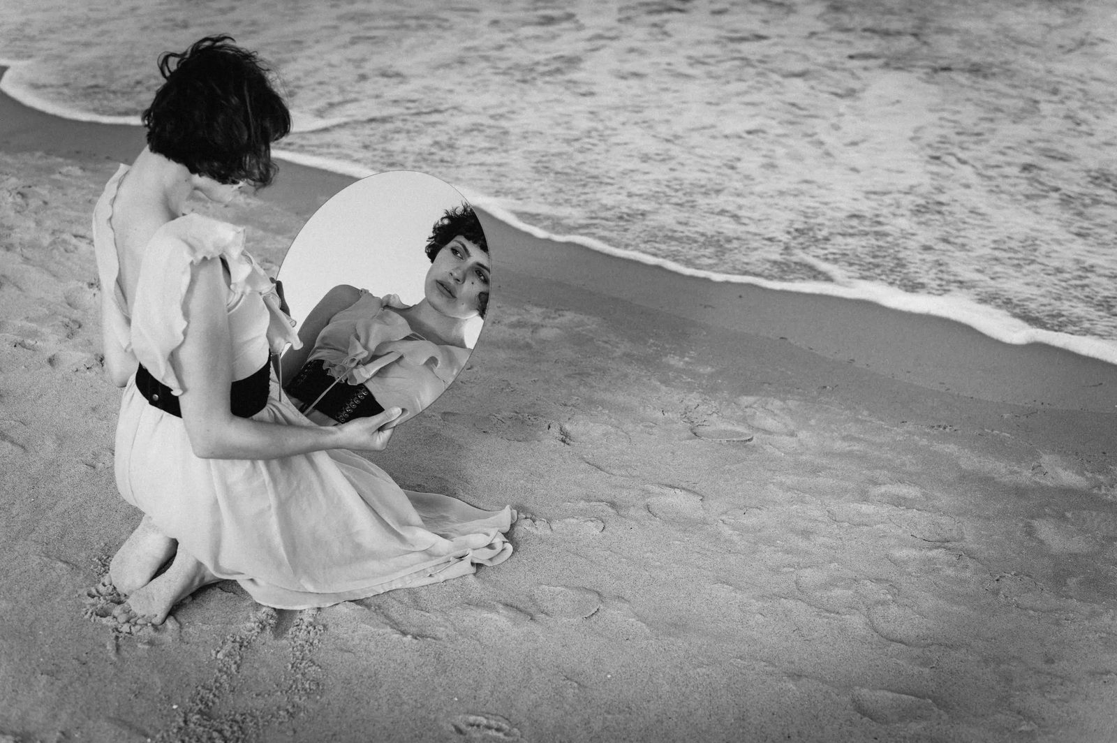 Im Gedanken – Frau mit Spiegel am Strand